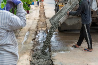 İnşaat alanında karışık beton dökümü. Kaldırımın yükseltilmesi sırasında çimento dökülüyor. Sokağa çelik takviyesi yerleştirdikten sonra beton döküp, hazır beton döküyorum.