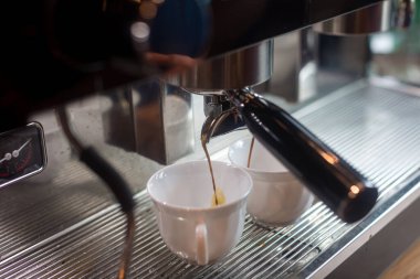 Profesyonel kahve makinesinden kahve çıkarma. Kahve makinesi taze kahve hazırlıyor ve restoranda, barda ya da barda fincanlara dökülüyor. Makineden espresso..