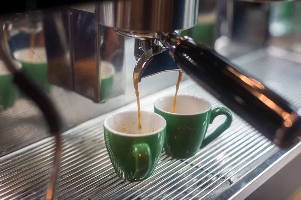Coffee extraction from professional coffee machine . coffee machine preparing fresh coffee and pouring into cups at restaurant, bar or pub. Espresso shot from machine.