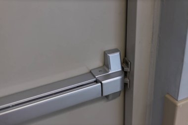 Acil çıkış kapısı. Kapalı kapı mandalı ve paslı acil çıkış kapısı. Panik çıkışı için parmaklıkları itin. Tek yönlü kapıyı aç. Beyaz kapı yangın çıkışı için çelik saplı.