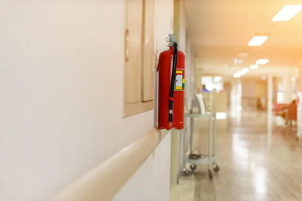 操作部门的灭火器 在建筑物的墙壁上安装一个灭火器 走廊内的化学干粉灭火器 墙上挂着一个红色的灭火器 — 图库照片