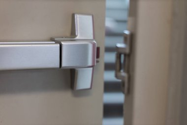 Acil çıkış kapısı. Kapalı kapı mandalı ve paslı acil çıkış kapısı. Panik çıkışı için parmaklıkları itin. Tek yönlü kapıyı aç. Beyaz kapı yangın çıkışı için çelik saplı.