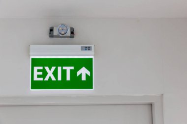 Kaçış yolunu gösteren yeşil acil çıkış işareti. Binadaki yangın çıkışı..