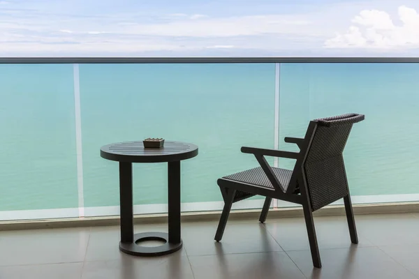 Table and chair with outdoor balcony and sea .The chair and table on balcony sea view. Chair with table set on balcony hotel room with ocean view background.