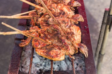 Kızarmış tavuk ya da Tayland usulü ızgara tavuk, ızgara tavuk. Tayland sokak yemeklerinde fırında ızgara tavuk. Izgarada kızarmış tavuk ve dumanlı mangal.