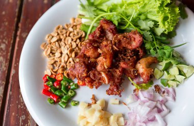 Kızarmış domuz kaburgası, yanında da sarımsak, biber ve fındık. En sevdiği koruma yiyeceği. Kızarmış ekşi domuz eti. Kızarmış mayalanmış domuz pirzolası lezzetli.