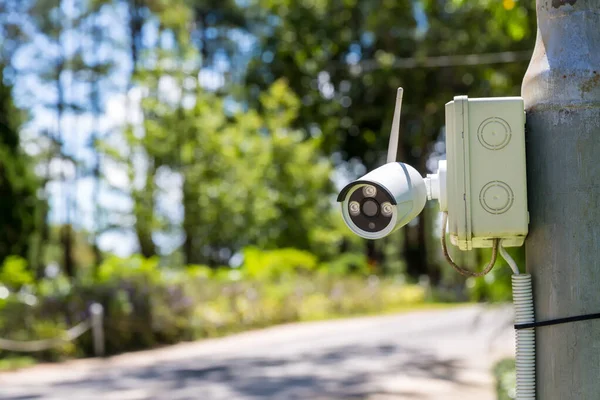 Evin dışındaki güvenlik kamerası güvenlik kamerası sistemi. Bulanık bir gece şehri manzarası. Duvardaki modern CCTV kamerası. Güvenli yaşam ya da varlık için ekipman sistemi hizmeti.