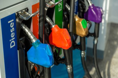 Yakıt Pompası, Benzin İstasyonu, Gasoline. Beyaz arka planda izole edilmiş renkli benzin pompası, sıcak güneş batımında hizmet veren benzin istasyonu. Asya 'da yakıt ikmal tesisi.