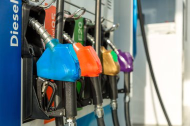 Yakıt Pompası, Benzin İstasyonu, Gasoline. Beyaz arka planda izole edilmiş renkli benzin pompası, sıcak güneş batımında hizmet veren benzin istasyonu. Asya 'da yakıt ikmal tesisi.
