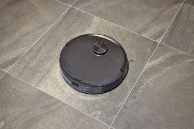 Yerdeki akıllı temizlik teknolojisinde robot elektrikli süpürge. Robot elektrik süpürgesi yerdeki tozu kaldırıyor. Sıradan bir dairede elektrikli süpürge. akıllı ev kavramı.