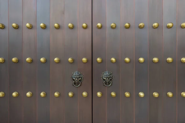 The door and knockers of Chinese temple. Ancient Asian door from temple. Chinese door. Oriental design of door of palace hall in Forbidden City.