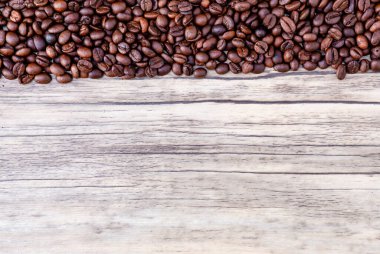 Ahşap arka planda kahve çekirdekleri. Bir yığın kahve. Ahşap arka planda kahve çekirdekleri. Üst Manzara. Boşluğu kopyala.