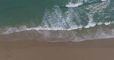 Metnin için fotokopi alanı olan turkuaz suyla çarpıcı güzellikteki deniz manzaralı bir kumsalın insansız hava aracı görüntüsü. Turkuaz suyla güzel bir kumsal, insansız hava aracı görüntüsü.