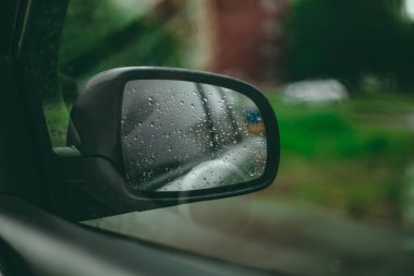 Yağmurlu hava, araba penceresinden manzara. Araba aynasında yağmur damlaları
