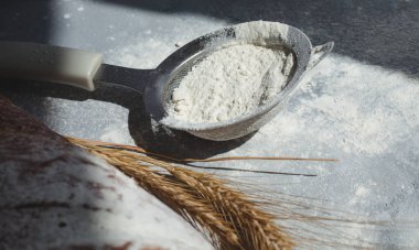 Gri arka planda un olan tahta kaşık. Yemek pişirme süreci, bir yazı için yer