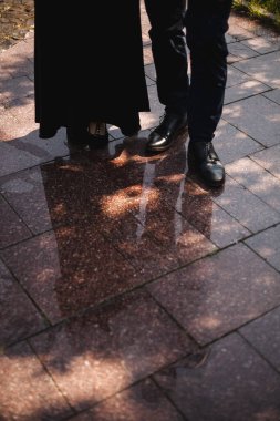 Suda bir çiftin yansıması. Odaklanan şık ayakkabılar