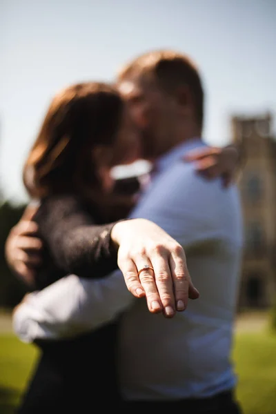 Ellerin yakın plan fotoğrafı. Arka planda sevgili bir çift, nişan günü. Adam bir teklif yaptı..