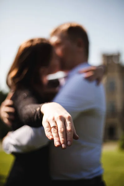 Ellerin yakın plan fotoğrafı. Arka planda sevgili bir çift, nişan günü. Adam bir teklif yaptı..