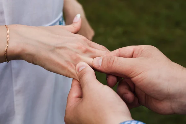Bir adam bir kadına alyans takar. Karı koca, düğün günü. Yakın plan fotoğraf. Altın yüzük