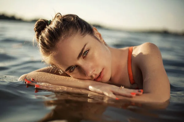 一个女孩在水里的时尚照片 海上一个漂亮姑娘的肖像照片 蓝色水中漂亮的黑发女孩的夏季时装肖像 免版税图库照片