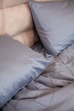 Yapılmamış boş yatak. Mavi çarşaf.