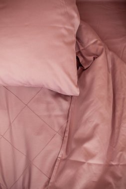 Yapılmamış boş yatak. Yatak örtüsü pembe..