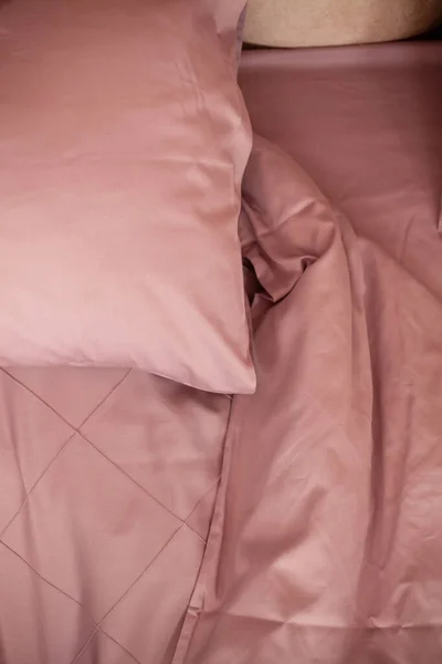 Yapılmamış boş yatak. Yatak örtüsü pembe..