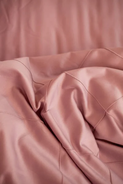 Yapılmamış boş yatak. Yatak örtüsü pembe..