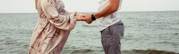 一对恋人牵着手在大海的背景上 特写照片 登记地点 — 图库照片