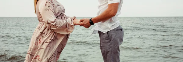 一对恋人牵着手在大海的背景上 特写照片 登记地点 图库图片