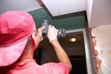 Duvarlar ve derleme doldurma ve bir oda yenileme sırasında alçı panoları yapıştırma.