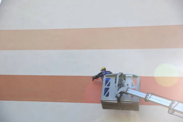 Painting the facade from at a height using a special jib.