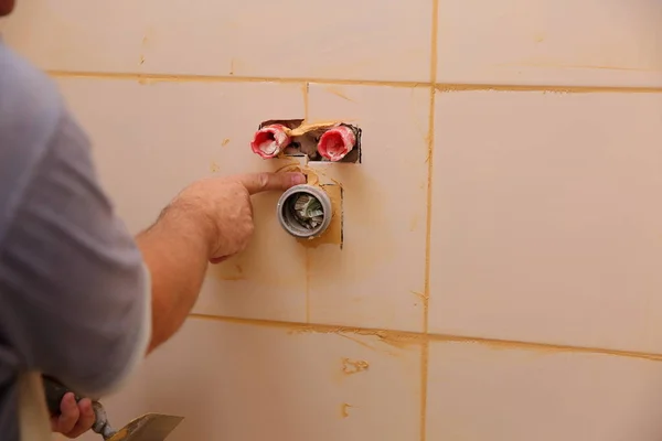 construction worker man repairing wall with tiles