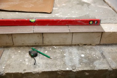 Planning the laying of terracotta on the stairs, while keeping an equal footing with the spirit level.