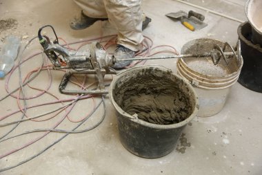 İnşaat işçisi döşeme yapıştırıcı ile birlikte su doğru oranlarda karışımları.