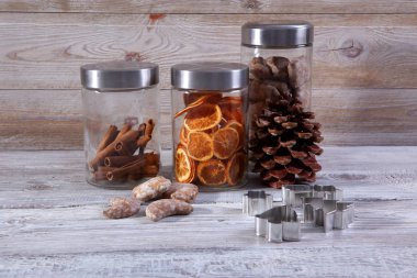 gri ahşap arka plan üzerinde ev yapımı noel çerezleri, tarçın ve kurutulmuş portakal dilimleri kavanoz