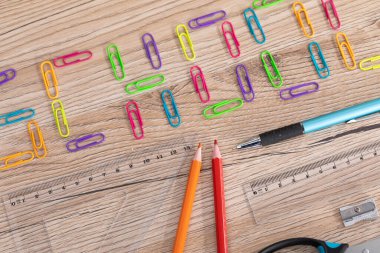 Renkli ofis ataçları. Yazı okulu. Beyazların tebeşiri. Tahta okul tezgahı. Okul aksesuarları.