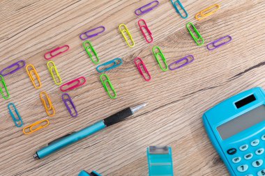 Yeni ofis aksesuarları ahşap bir masanın üstüne eşit olarak yerleştirilmiş..