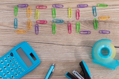 Yeni ofis aksesuarları ahşap bir masanın üstüne eşit olarak yerleştirilmiş..