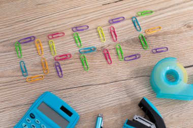 Yeni ofis aksesuarları ahşap bir masanın üstüne eşit olarak yerleştirilmiş..