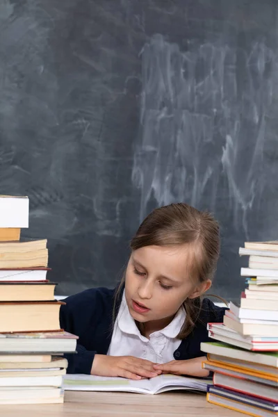 Het Meisje Zit Tussen Een Stapel Boeken Leren Voor Het — Stockfoto