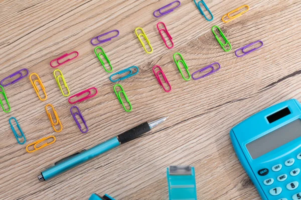 Yeni ofis aksesuarları ahşap bir masanın üstüne eşit olarak yerleştirilmiş..