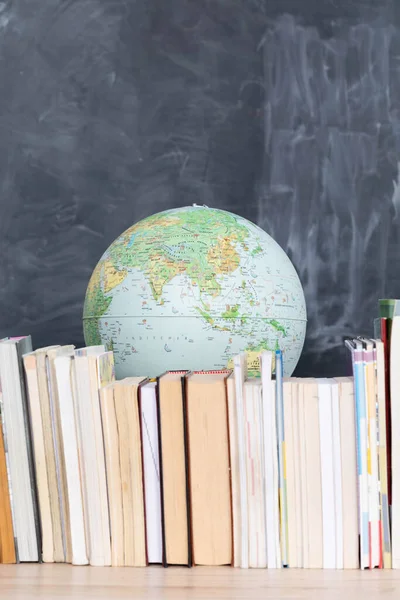 Geography lesson. A globe among a large number of school books.