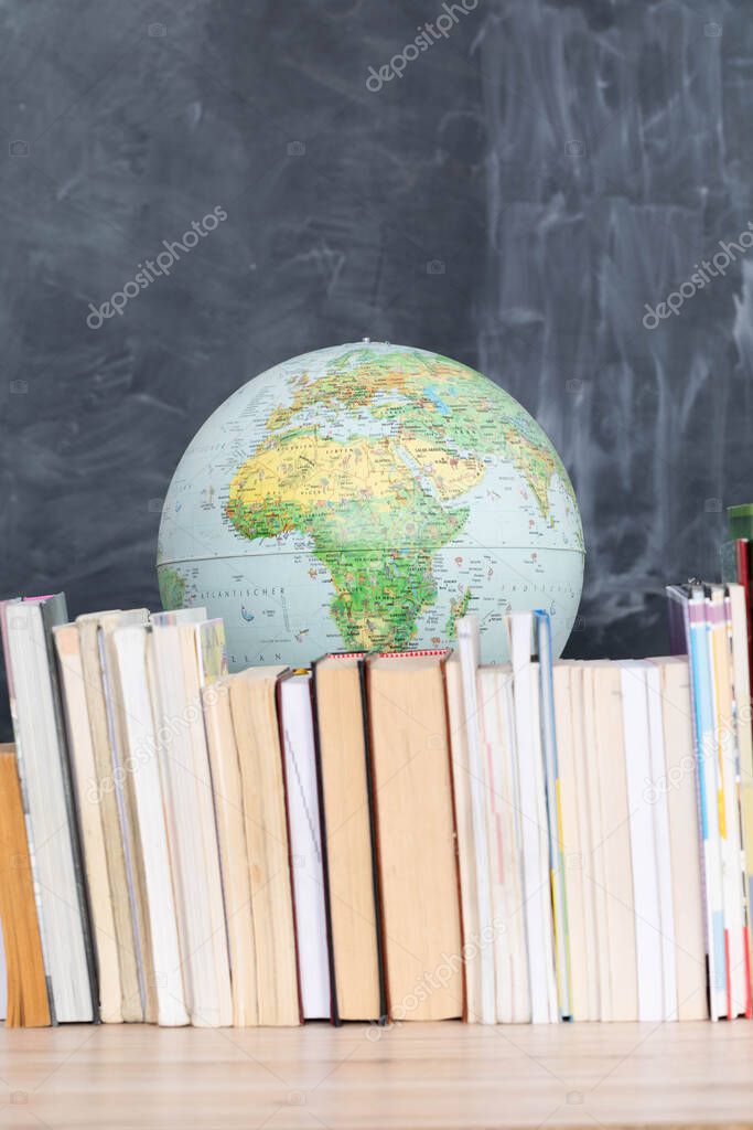 Geography lesson. A globe among a large number of school books.