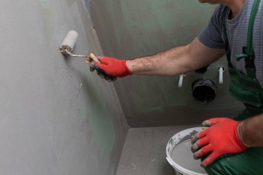 Banyo tadilatı. İnşaat işçisi. Mineral nem yalıtımı. İş sırasında..
