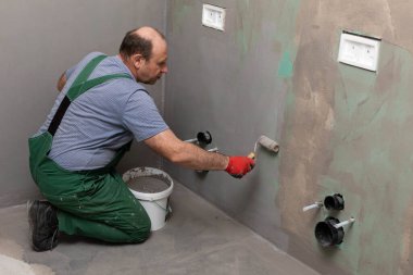 Banyo tadilatı. İnşaat işçisi. Mineral nem yalıtımı. İş sırasında..