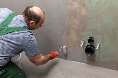Banyo tadilatı. İnşaat işçisi. Mineral nem yalıtımı. İş sırasında..
