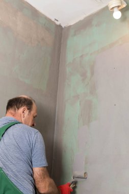 Banyo tadilatı. İnşaat işçisi. Mineral nem yalıtımı. İş sırasında..