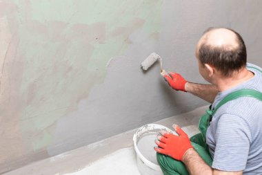Banyo tadilatı. İnşaat işçisi. Mineral nem yalıtımı. İş sırasında..