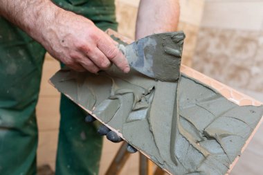 Kalın çimento bazlı yapıştırıcı. İçişleri için profesyonel bir çalışan. Döşemeler - seramik fayans.